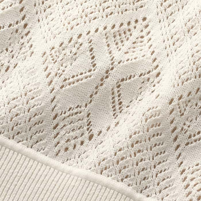 100% organic cotton knitted in a delicate lace stitch with fine ribbed trims and delicate armhole scalloping.
