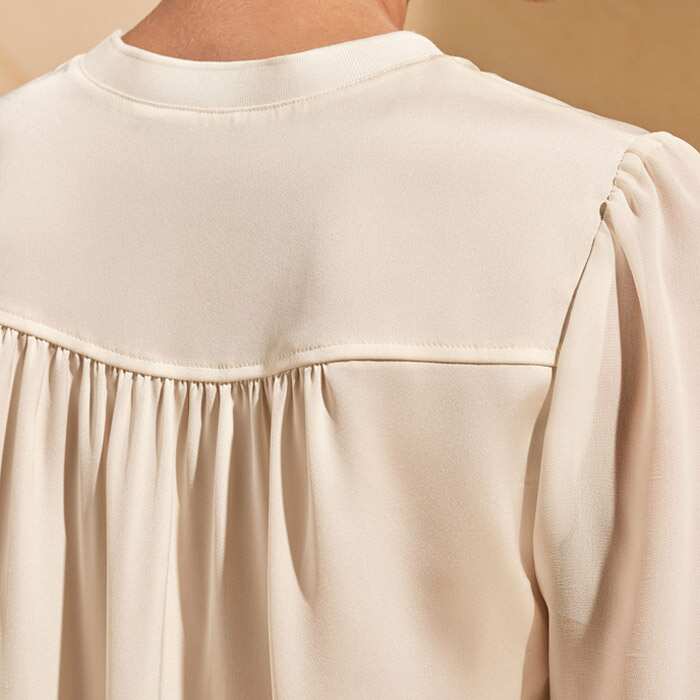 Feminine gathers at back yoke and sleeve head add subtle feminine details to this piece.