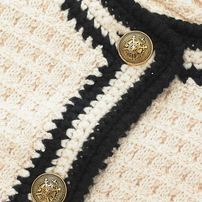 Natural, breathable chunky 5gg cotton bouclé yarn knitted in a compact stitch.
Features vintage-inspired military buttons.